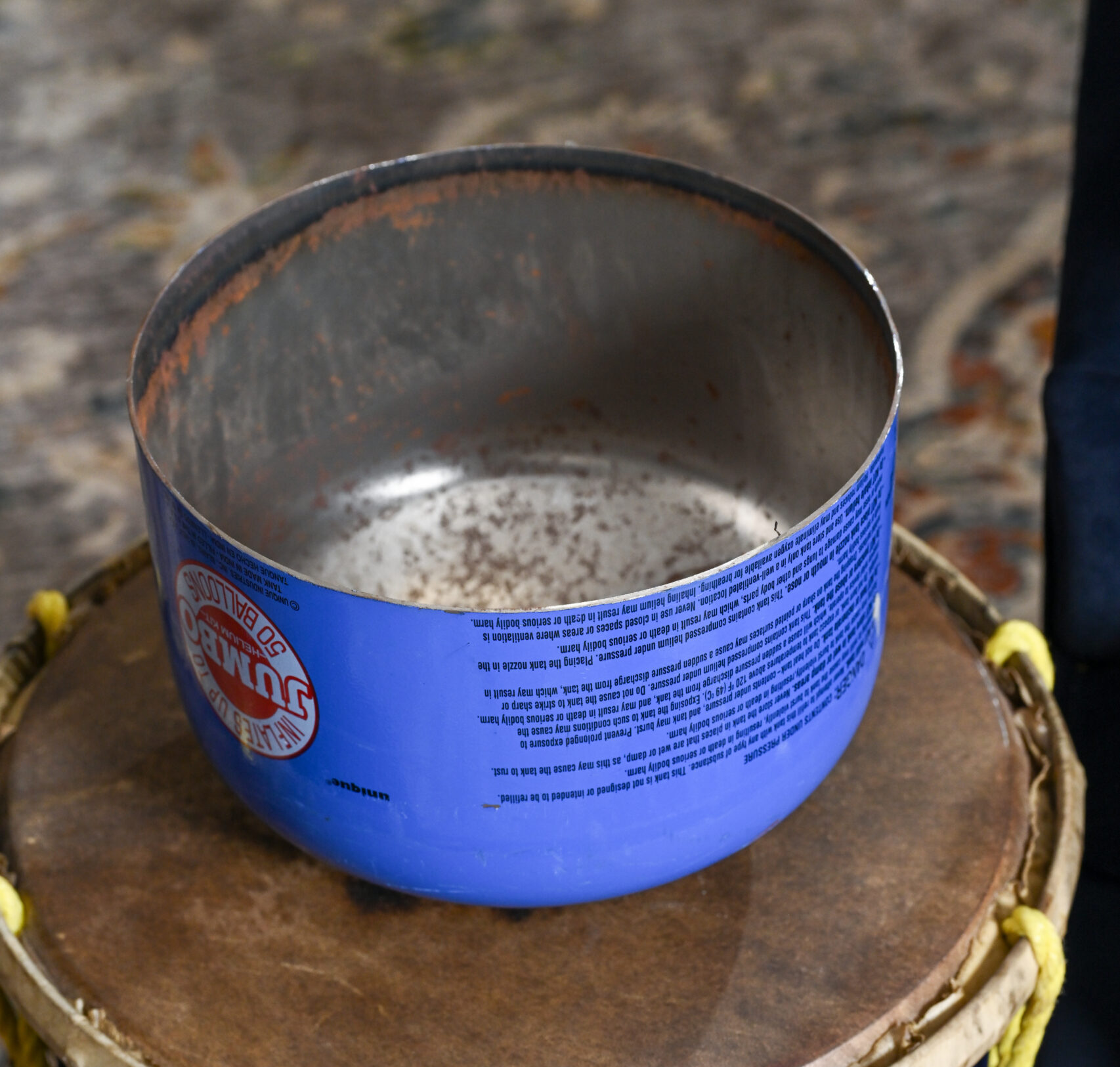 A bowl-shaped metal container sits on top of a drum