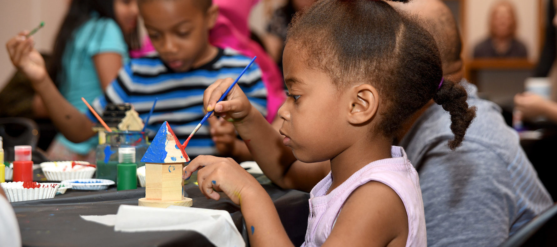 children painting a bird house