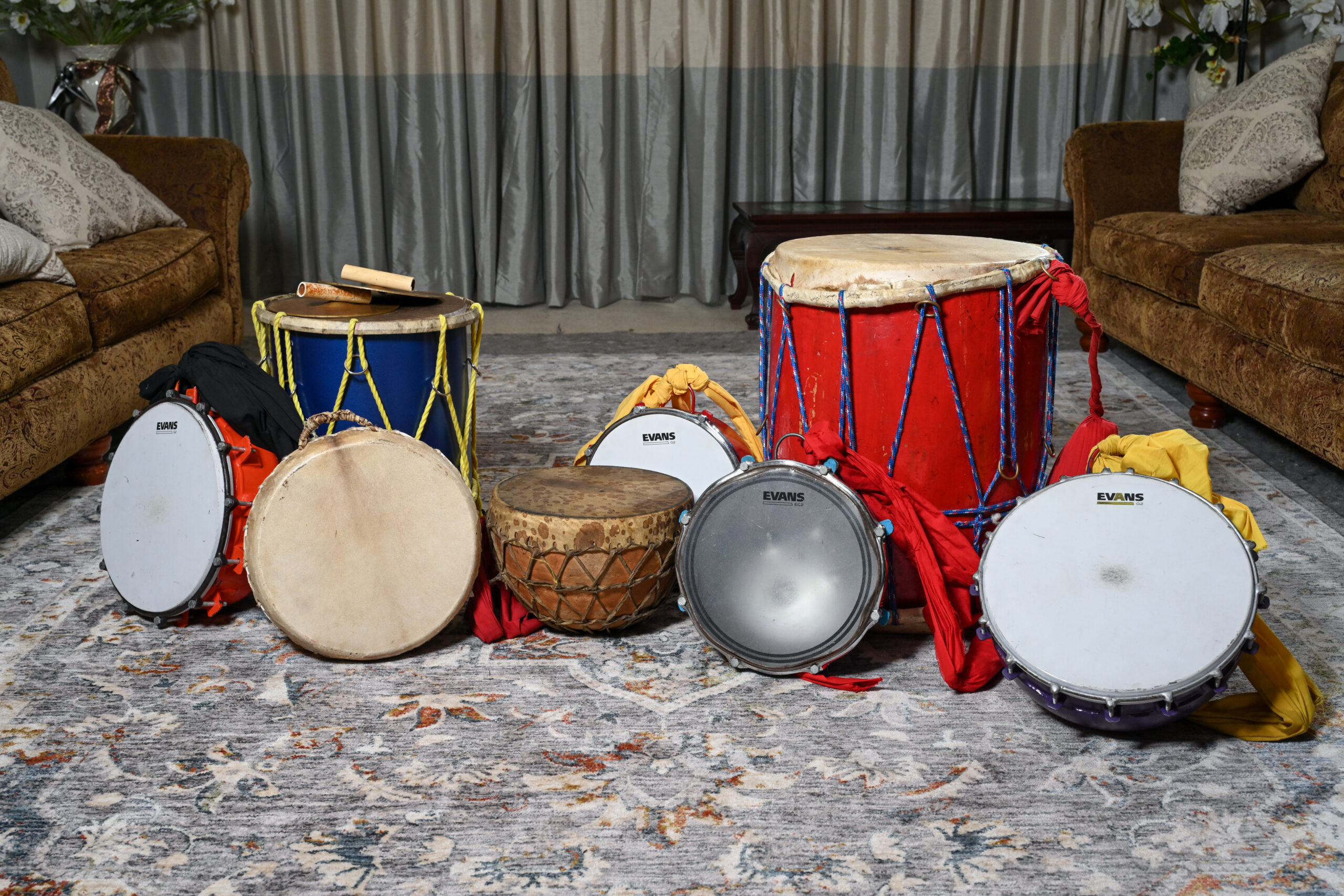 An assortment of different sized drums rest on the ground.