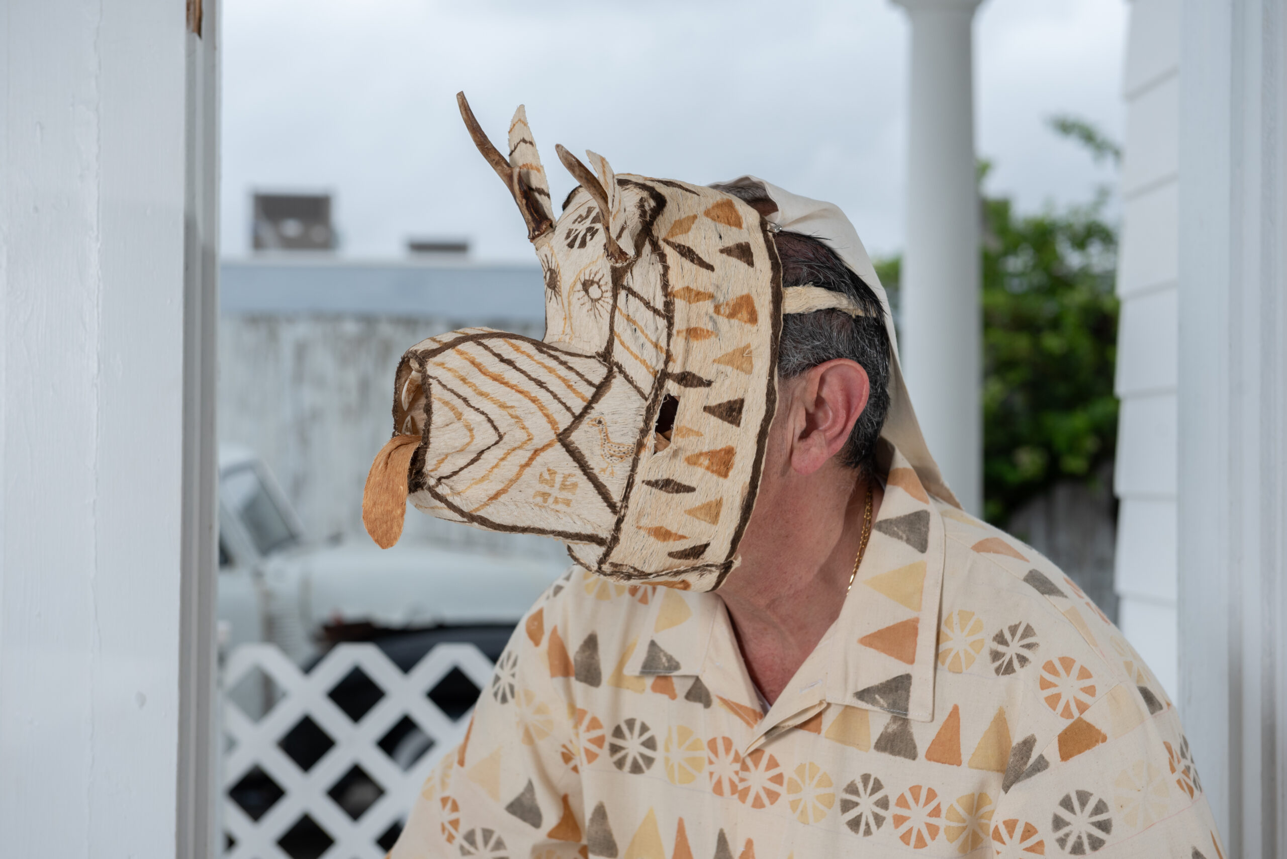 A close up shot of a beige and brown mask resembling a deer. The mask is made from a fibrous material and has brown and light orange accents.