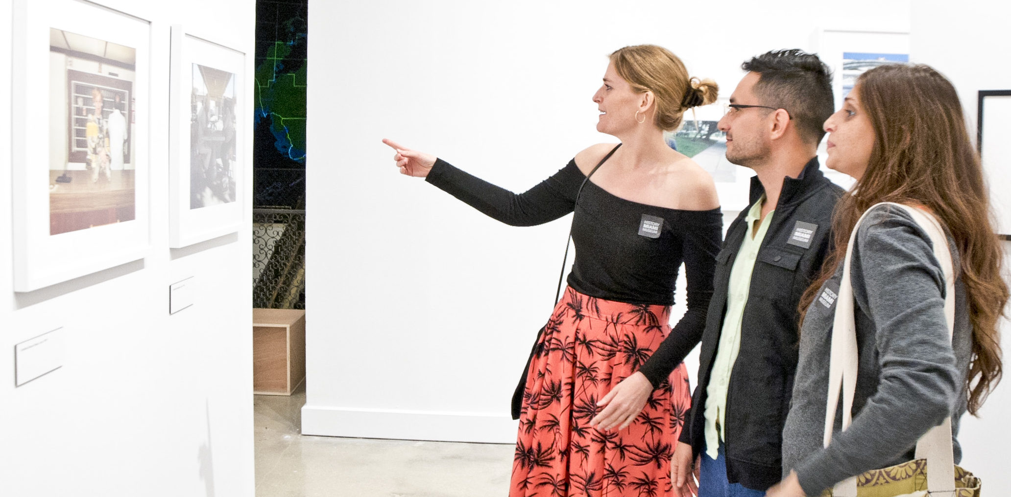 three people viewing artwork