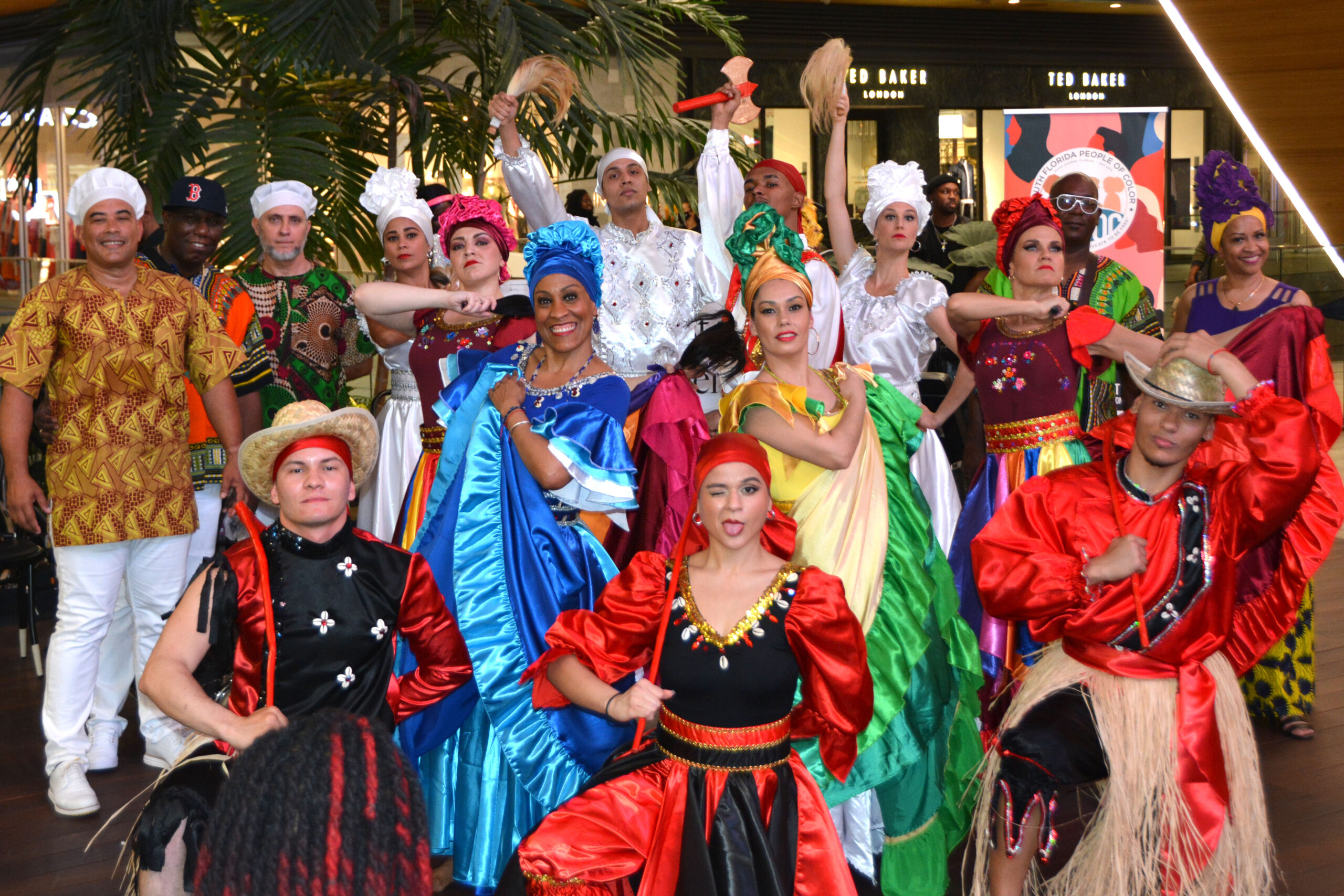 Dance ensemble of men and women pose in different styles of dance costumes.