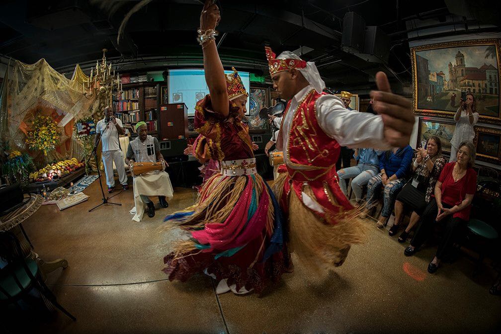 Two dancers perform Afro-Cuban religious dances dressed in colorful costumes representing deities called orishas