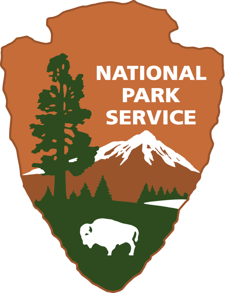 National Park Service logo; a brown arrowhead with a drawing of a tree, buffalo, and mountain in the distance.