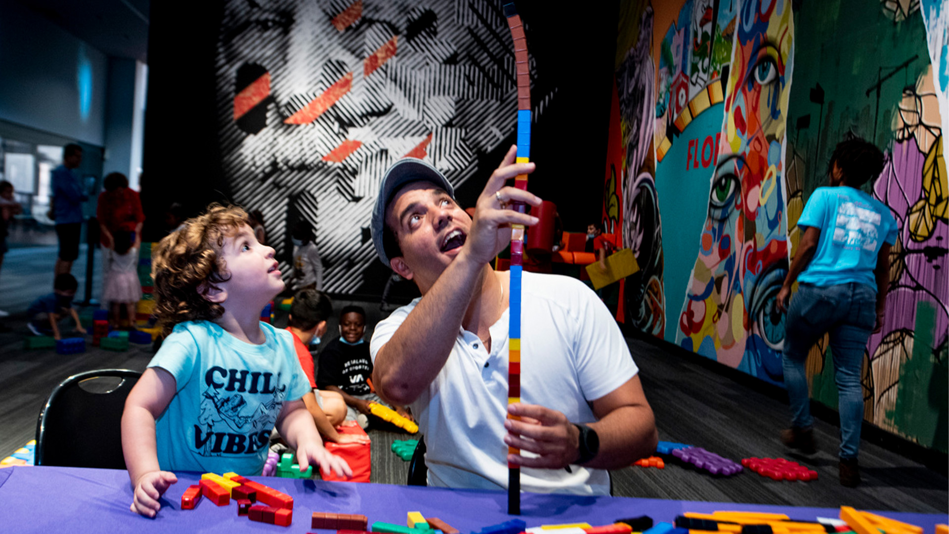 Parent and child playing with building blocks.
