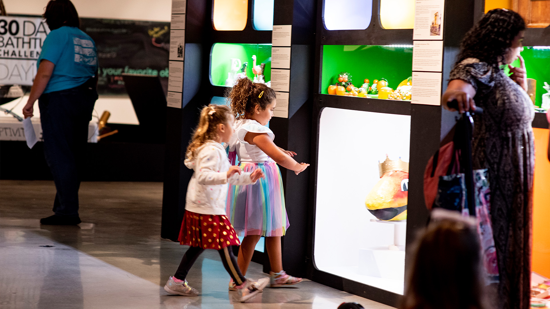Children looking at artifacts on the wall inside case.