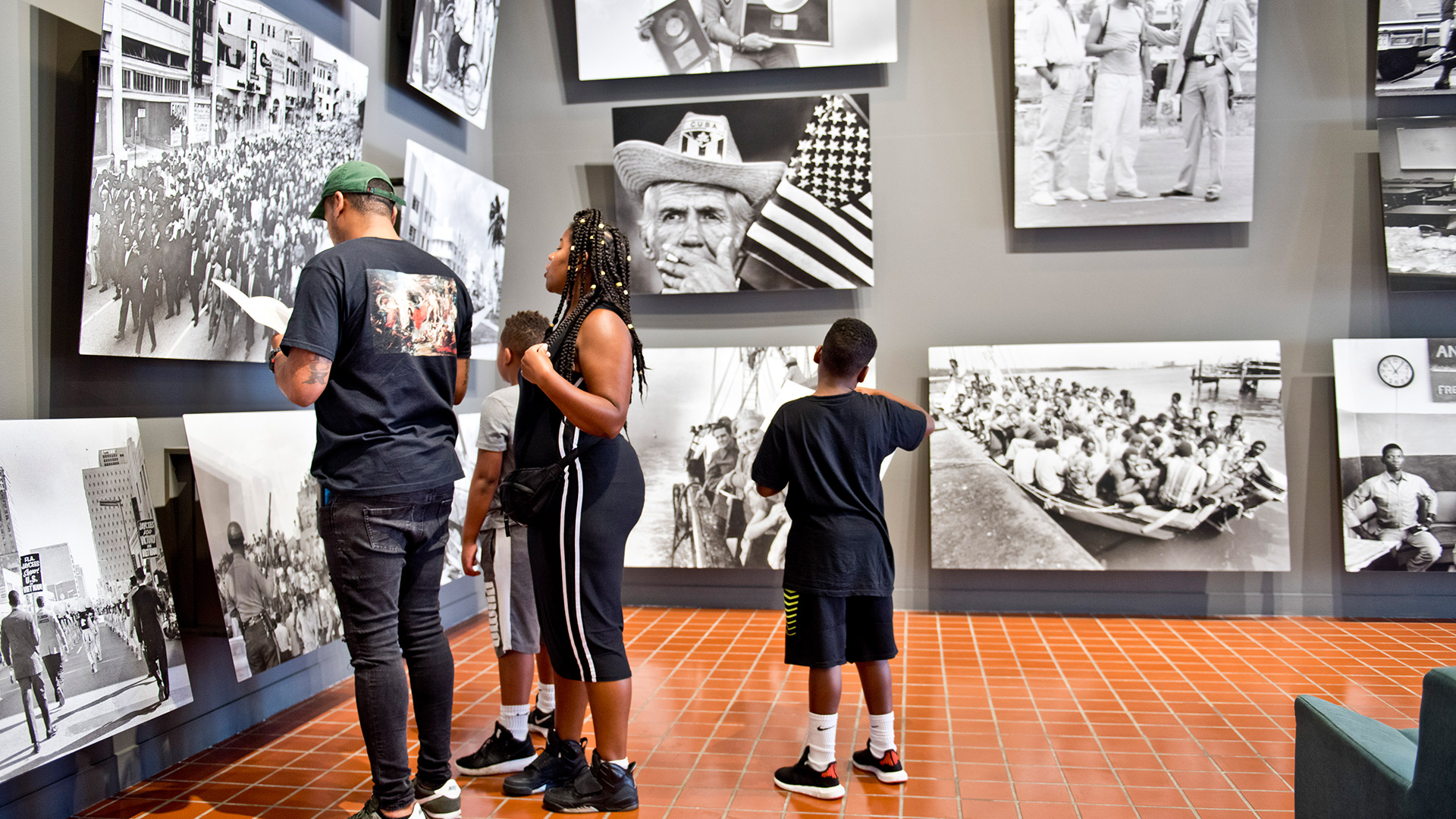 Family looking at images hanging on the wall.