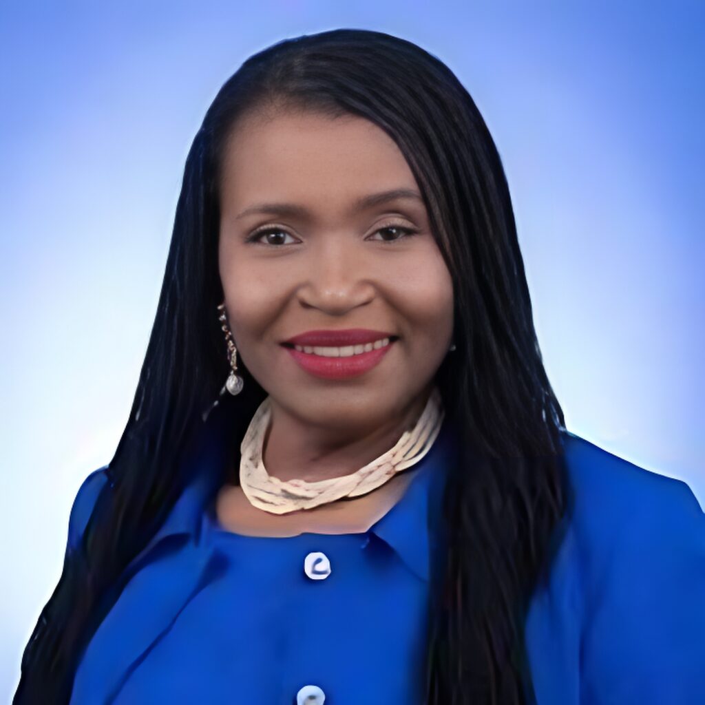 A person wearing a bright blue top, necklace, and red lipstick with dark hair smiles to the camera.